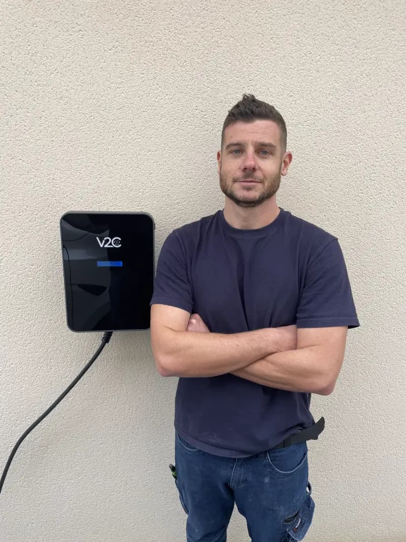 Fabien, artisan installateur certifié IRVE, devant une borne de recharge V2C Trydan